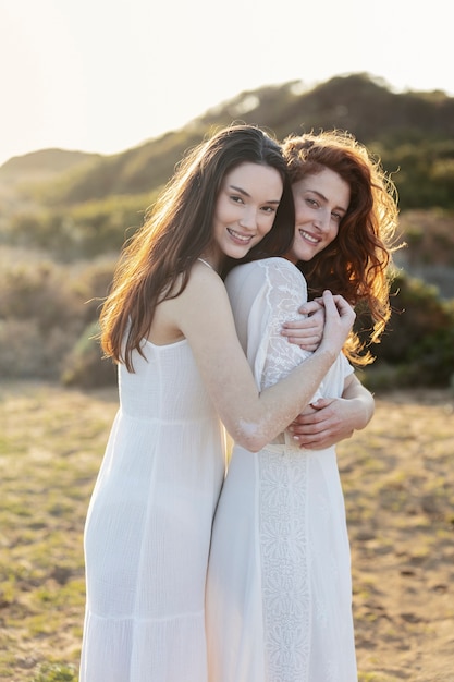 Donne sorridenti del colpo medio che si abbracciano all'aperto