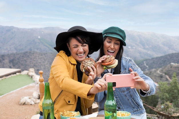 Foto donne sorridenti del colpo medio che prendono selfie