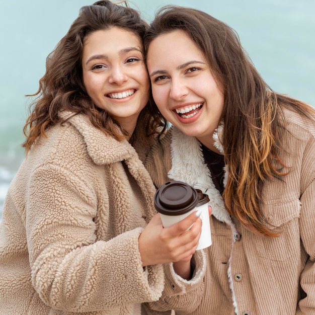 Medium shot smiley women with coffee cups