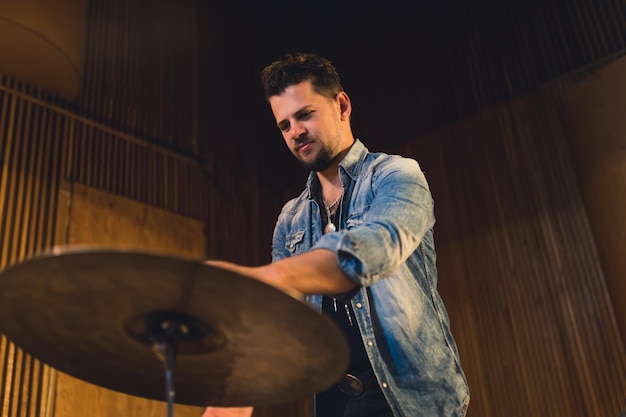 Medium shot van een jonge drummer die speelt in een repetitiestudio voor jonge artiesten.