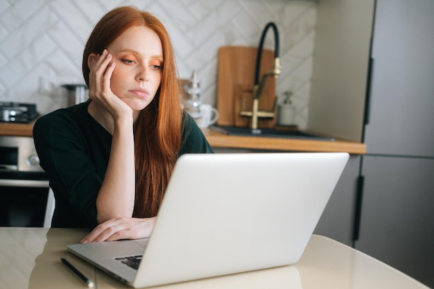 Medium shot van verveelde jonge vrouwelijke kantoormedewerker, moe, ongemotiveerd en ongeïnteresseerd in saai werk met