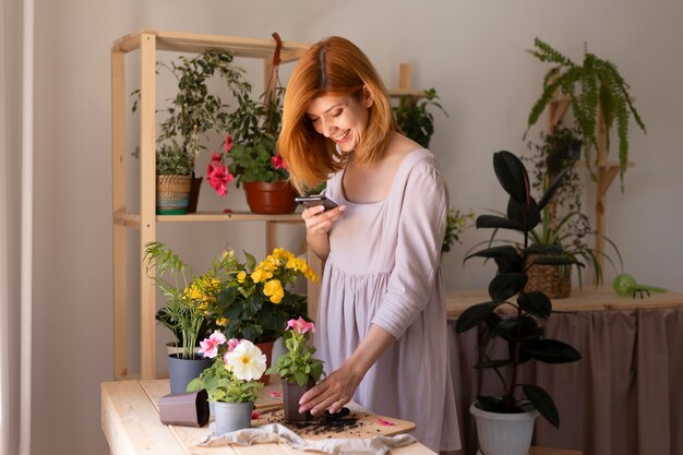 Medium shot vrouw die foto's maakt met telefoon