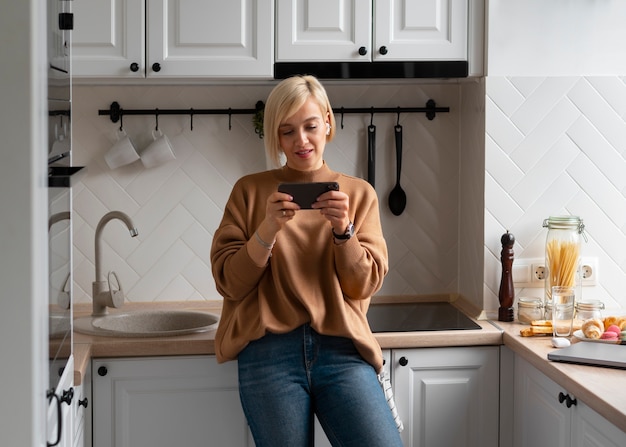 Foto medium shot vrouw die met haar telefoon speelt