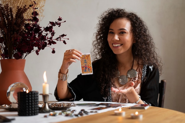 Foto medium shot vrouw die tarot leest aan tafel