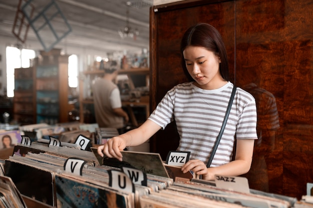 Foto medium shot vrouw die vinylplaten controleert