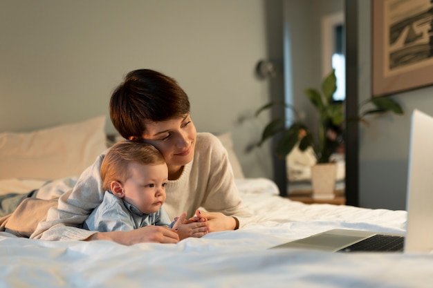 Medium shot vrouw en baby kijken naar laptop