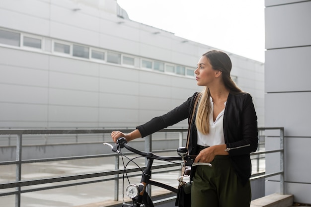 Foto medium shot vrouw met fiets wegkijken