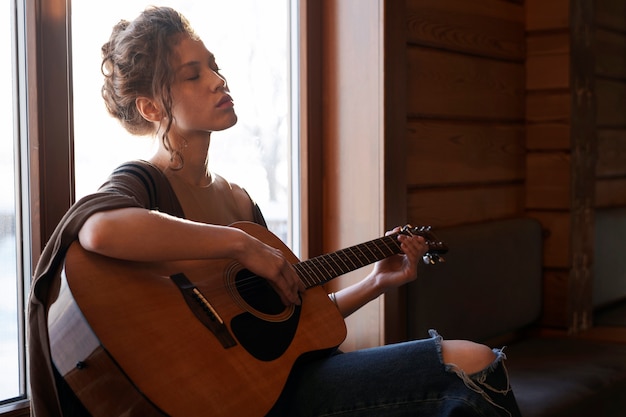 Foto medium shot vrouw met gitaar.