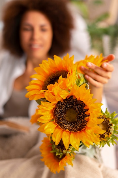 Foto medium shot vrouw met prachtige zonnebloemen