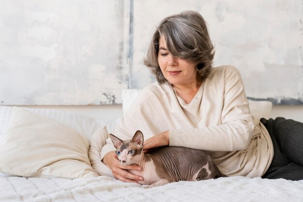 猫とベッドでミディアムショットの女性