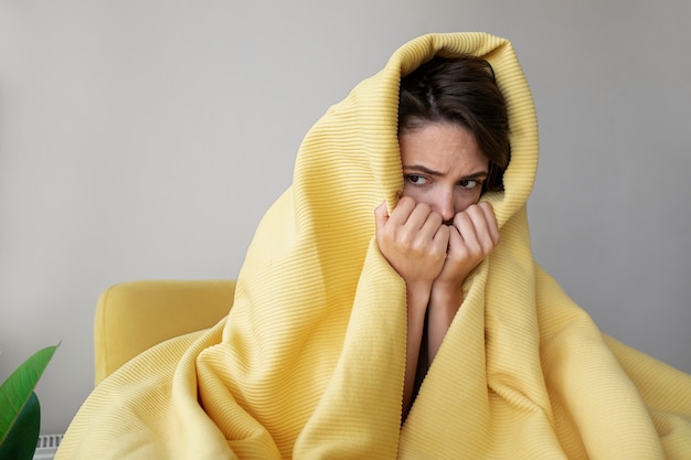 Medium shot woman covering with blanket