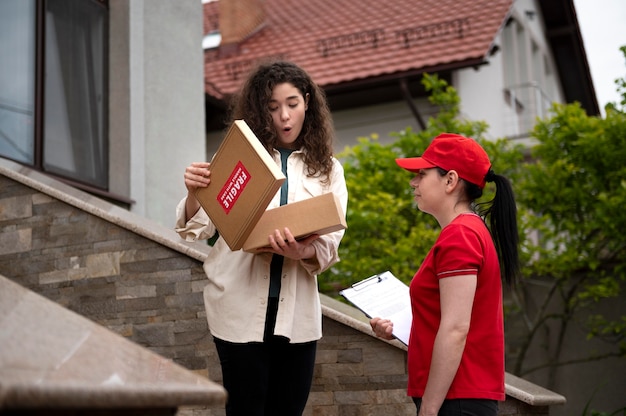 Photo medium shot woman delivering pack at home