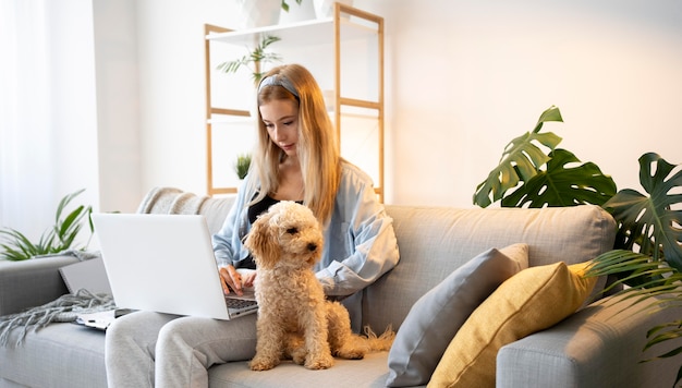 ミディアムショットの女性とソファの上の犬