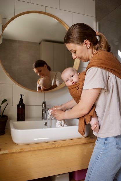 Foto donna del colpo medio che fa le faccende con il bambino