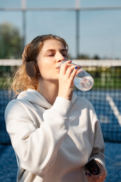 写真 水を飲む女性のミディアムショット