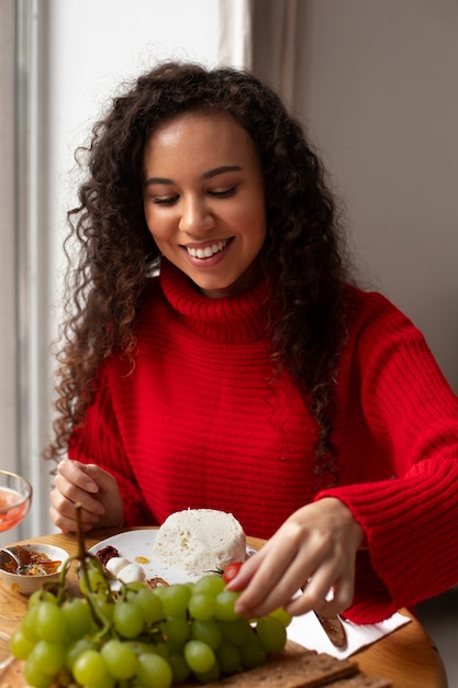 フレッシュチーズを食べるミディアムショットの女性