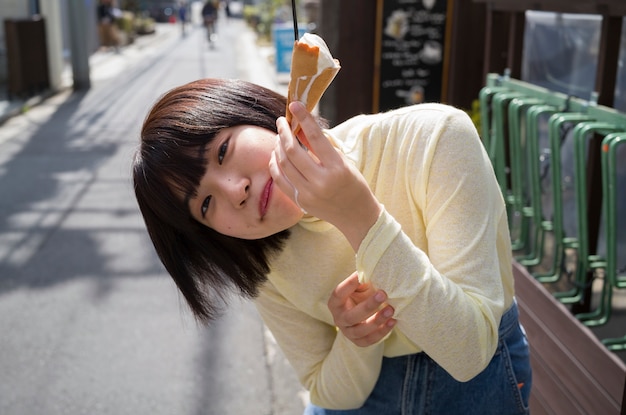 Foto donna del colpo medio che mangia il gelato