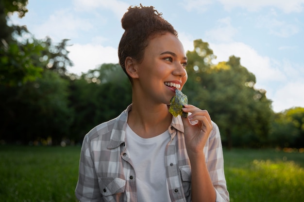 Photo medium shot woman  eating seaweed snack