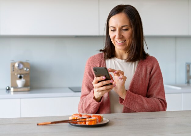 写真 家で寿司を食べるミディアムショットの女性