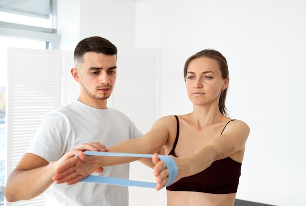 Medium shot woman exercising with elastic band