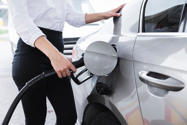 Colpo medio della donna che alimenta auto