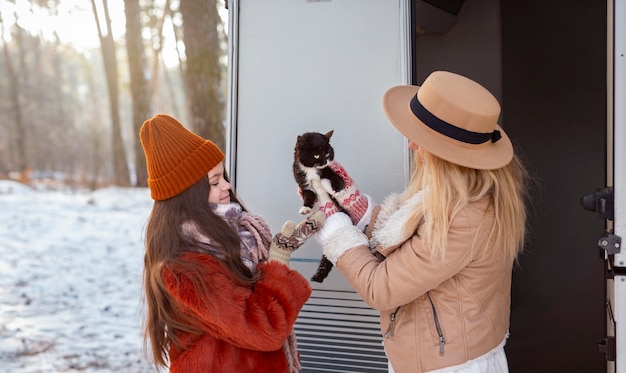 Gatto della holding della ragazza e della donna del colpo medio