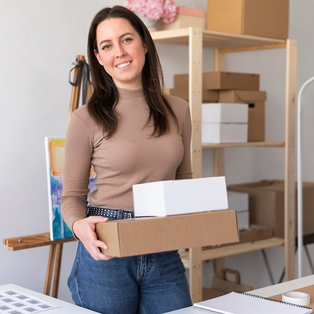 Medium shot woman holding boxes