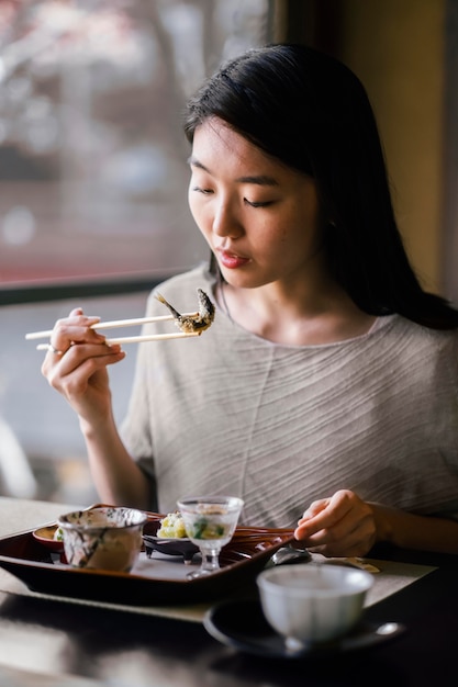 Medium shot woman holding chopsticks