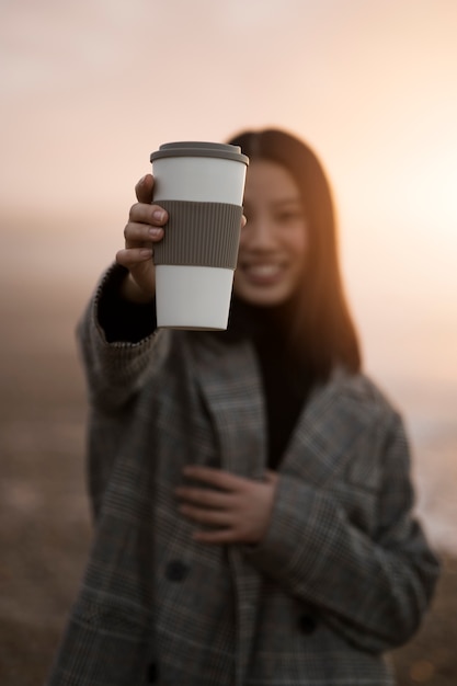 写真 コーヒーカップを保持しているミディアムショットの女性