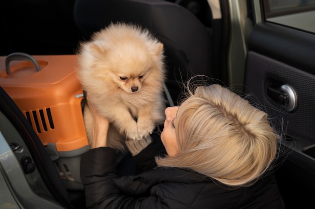 写真 かわいい犬を抱いたミディアムショットの女性