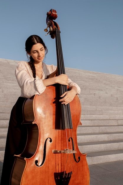 Photo medium shot woman holding duble bass