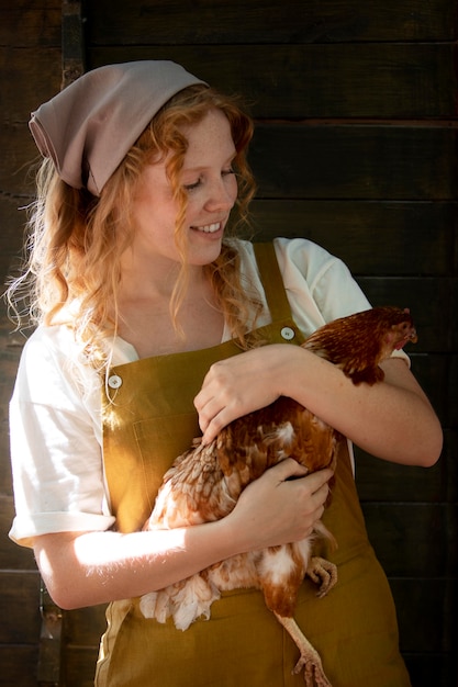 Medium shot woman holding hen