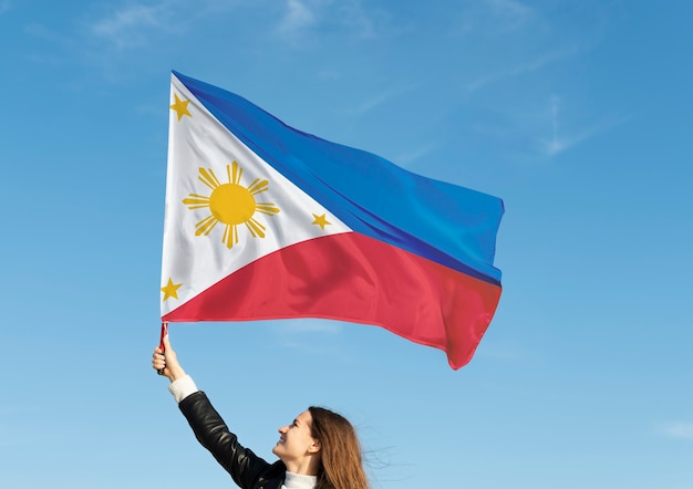 フィリピンの旗を保持しているミディアムショットの女性