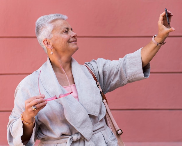 Foto donna con colpo medio che tiene il telefono