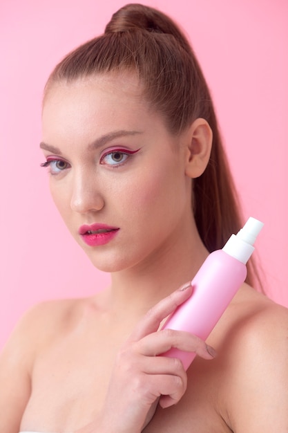 Photo medium shot woman holding pink bottle