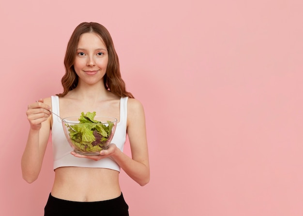 Medium shot woman holding salad bowl