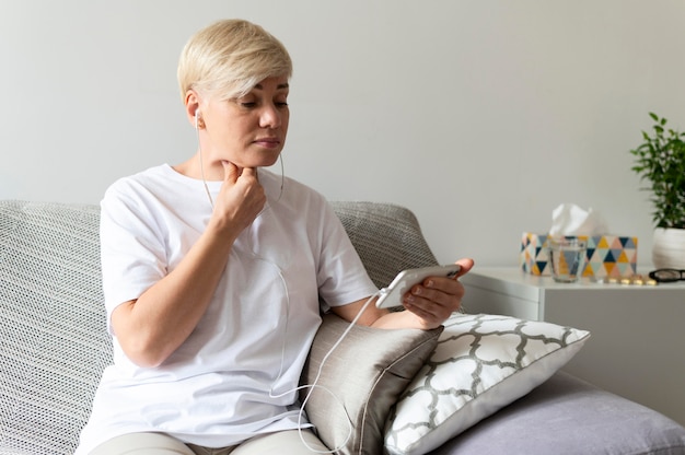 Medium shot woman holding smartphone