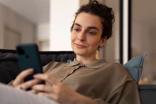 Medium shot woman holding smartphone