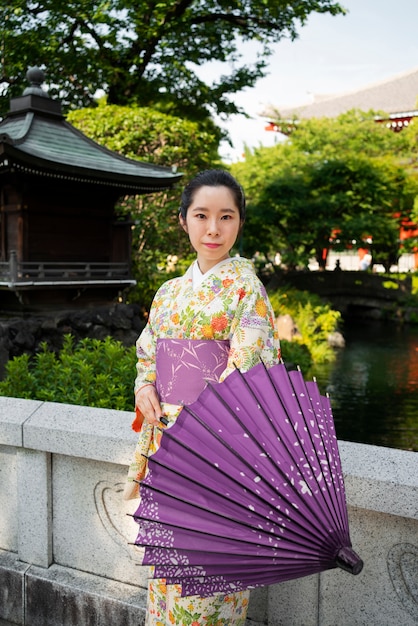 Medium shot woman holding wagasa umbrella