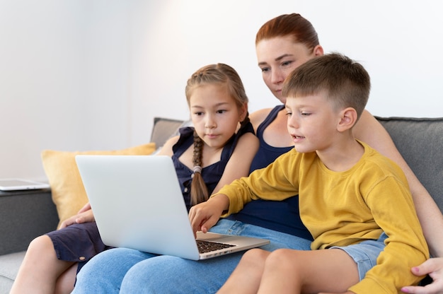 Colpo medio donna e bambini con laptop