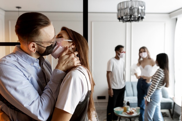 Photo medium shot woman and man kissing with masks