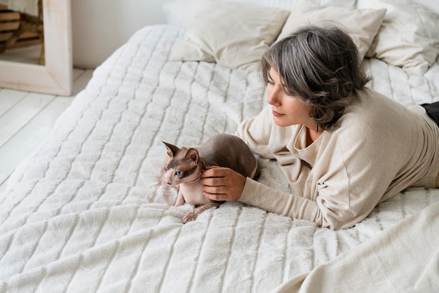 Donna a tiro medio che accarezza un simpatico gatto