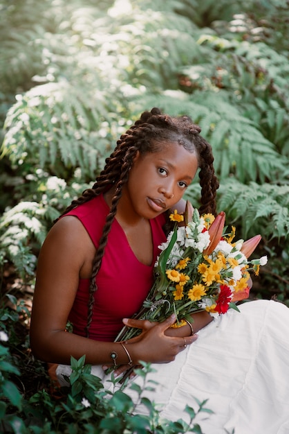 写真 花でポーズをとるミディアムショットの女性