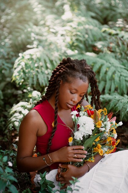 写真 花でポーズをとるミディアムショットの女性