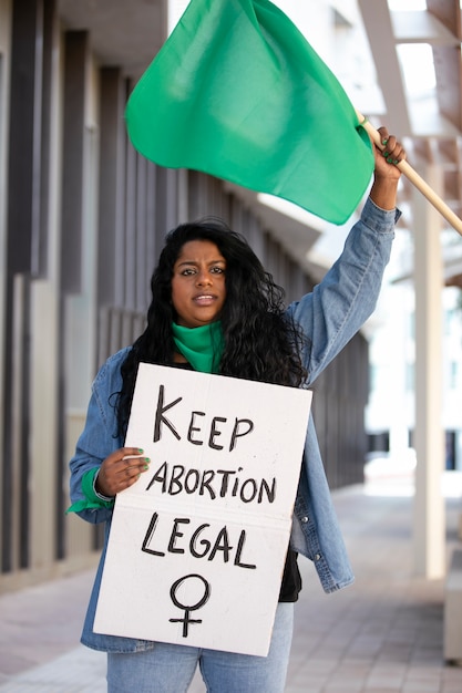 Foto donna del colpo medio che protesta all'aperto