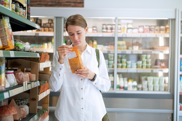 Photo medium shot woman reading label