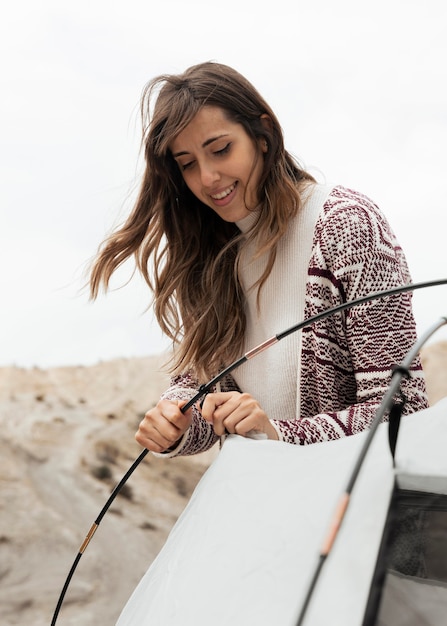 Medium shot woman setting up a tent