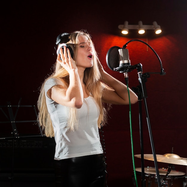 Medium shot of woman singing with her eyes closed