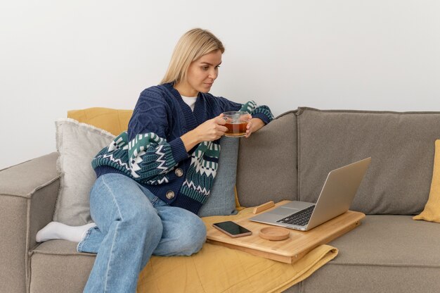 Medium shot woman sitting on couch