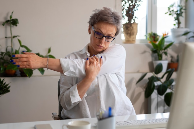 Photo medium shot woman stretching at desk